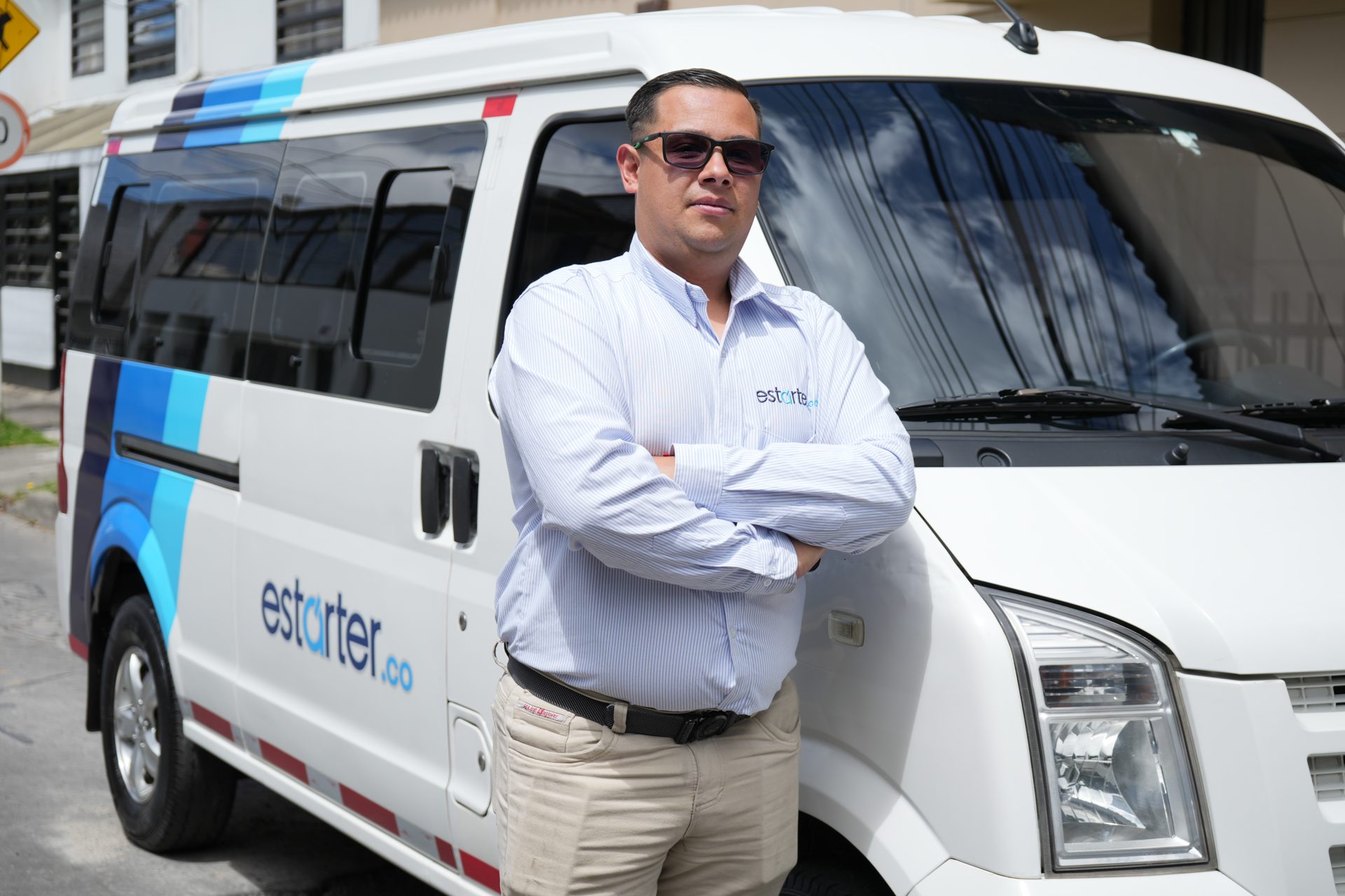 Conductor profesional de Estárter junto a una van corporativa