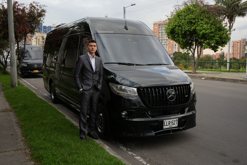 Conductor de Estárter junto a una camioneta negra en Bogotá